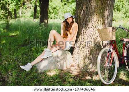 young girl posing in the park with bicycle