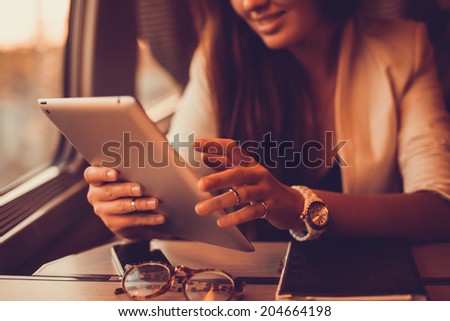 young girl working in the train in tablet, ipad serfing, apple style,