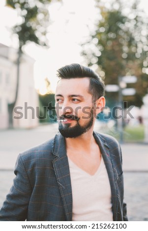 young man smokes a cigarette on the street