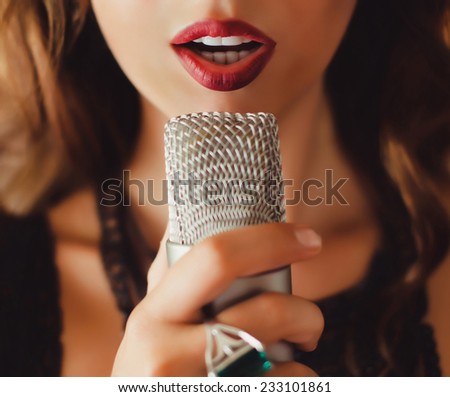 beautiful girl singing into a microphone