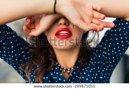 beautiful girl with red lips covered his eyes with his hands