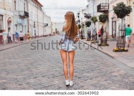outdoor girl making selfie on retro camera,walking on city laughing going crazy and have great time,walking on the city.Instagram bright colors,hairstyle,hight heels,sneakers,toned colors