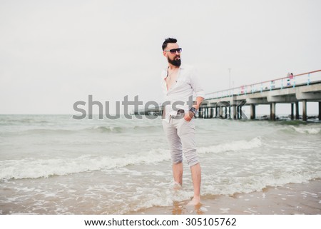 summer outdoor lifestyle image of young traveler handsome bearded man, wearing bright white shorts and black stylish hipster sunglasses,freedom ready for adventures.California beach,florida,east coast