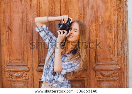 Summer outdoor portrait of stunning elegant woman, wearing classic luxury clothes and accessorizes,posing on the street, warm colors.city streets,old retro camera,adventure,hiker