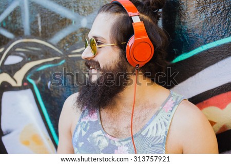Bearded man,lifestyle portrait of hipster man,cool beard hairstyle.mans haircut.Stylish man posing with cool hairstyle,wall,ready to car trip.Happy and active,Young sportsman,California east coast
