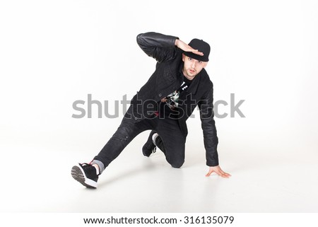 Active young black male dancing hip hop style in an urban setting. He is wearing a blue hoodie and is on a concrete background with copyspace.White background,studio action,freestyler