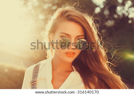 Close up summer portrait of beautiful young teen hipster girl with colored hair and bright make up, wearing trendy bright t-shirt and hipster glasses, posing at city with american flag,freedom concept