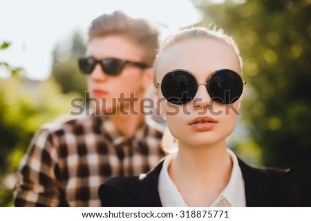 Close up fashion portrait of young couple posing on the city street in summer style clothes, retro sunglasses,fashionable couple in sunglasses,trendy outfits,autumn clothes,sunglasses fashion,black