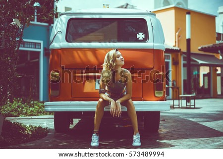 Beach Lifestyle, Beautiful Surfer Girl with Classic Vintage Surf Van on the Beach at Sunset,summer holidays, road trip,vacation,travel and people concept - smiling young hippie friends in minivan car