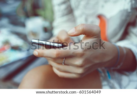Close up of women\'s hands holding cell telephone with blank copy space scree for your advertising text message or promotional content, hipster girl watching video on mobile phone during coffee break