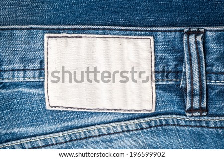 Blank fabric jeans white label sewed on a blue jeans.
