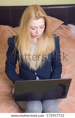 business lady with a laptop is sitting on the bed
