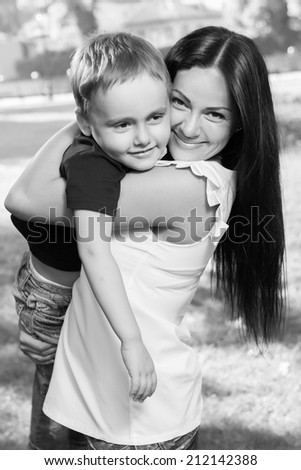 young mother holds her son in her arms in the park