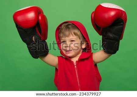 little boy in boxing gloves on a green background