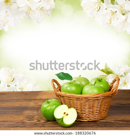 Photo of green apples in basket with apple blossom background