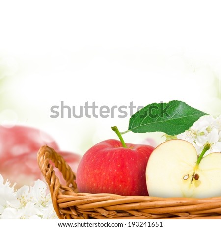 Photo of red apples in basket with apple blossom background