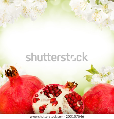 Photo of pomegranate and slice with blossom background