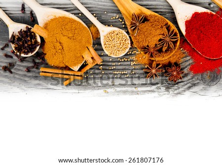 Photo of spoons with spice on wooden board with white space for text