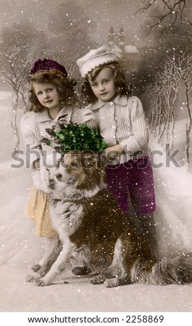 Children posing in the snow with their dog - a circa 1919 vintage hand-tinted photograph (studio set-up with a painted backdrop and fake snow falling).