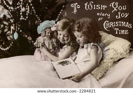 stock photo Two little girls reading a bettime story a 1909 vintage hand