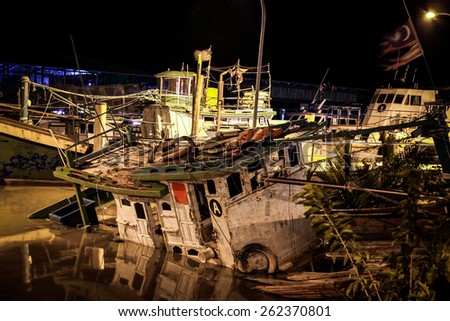 Moored boat sank in the harbor at night