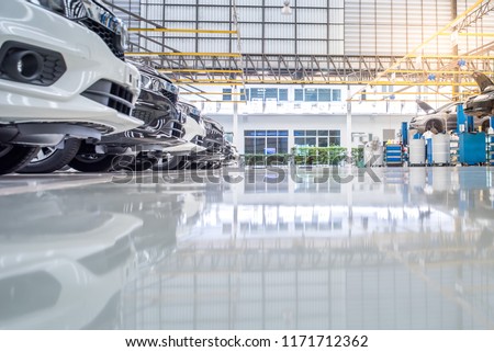interior car-care center. The electric lift for cars in the service put on the epoxy floor in new car factory service