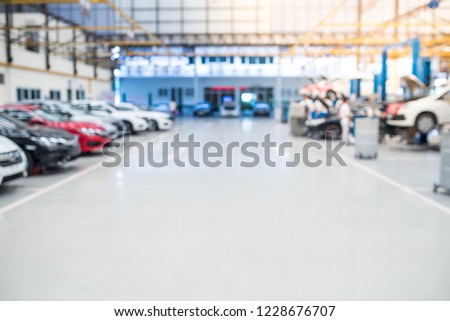Car raised on car lift in auto service, blurred background for industry