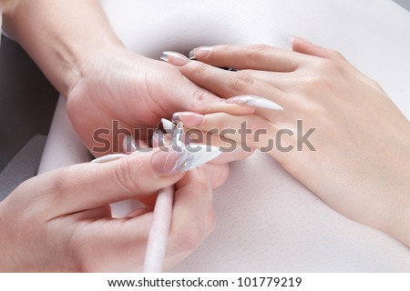 Manicure. Master make nail extension: drawing of the camouflage gel