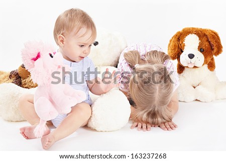 Two children with soft toys on a white background