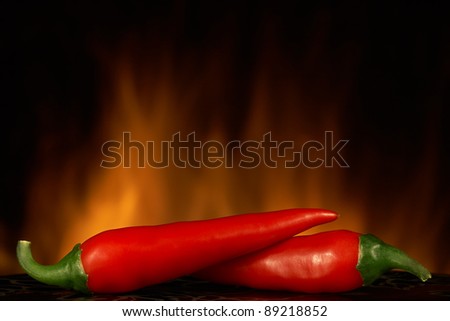 Red hot peppers on fire background