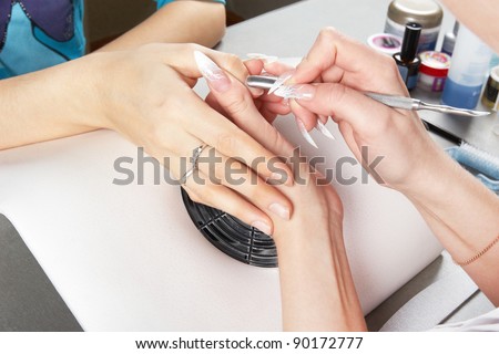 Manicure. Moving aside cuticle from the surface of the nail