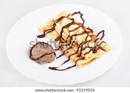 Thin pancakes with banana, ice cream and chocolate