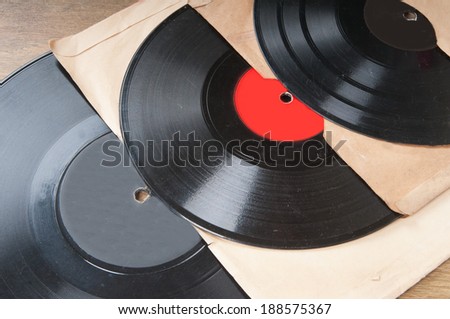 Vintage vinyl records in envelopes on wooden table
