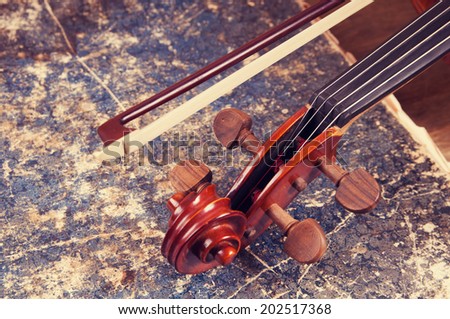 Violin, bow and old book table