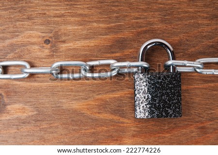 Wooden surface with chains and lock, concept of security