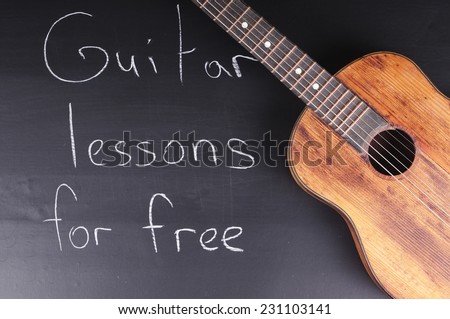 Old guitar on the chalkboard and the words \