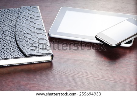 black notebook, tablet and on phone