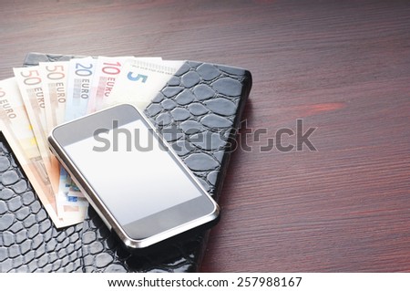 money, phone and notebook on the table