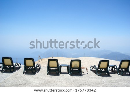 Chairs in the mountains. Rest and relaxation. Height, mountains and sky horizon.