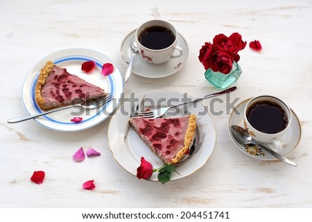Strawberry tart with black tea,roses and rose petals horizontal