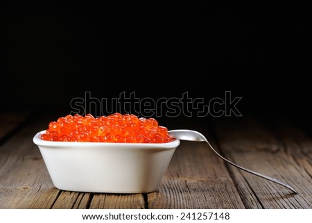 Red caviar in white bowl with silver spoon
