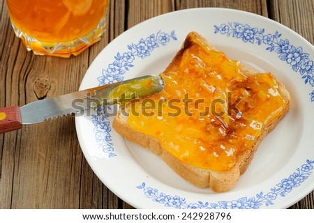 Toast with orange marmalade on wooden background