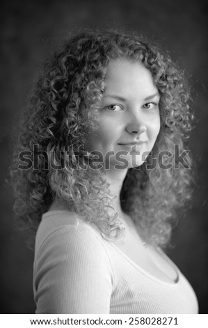 Smiling fairy woman with curly hair, big breast, low neck decollete on dark grey background black&white