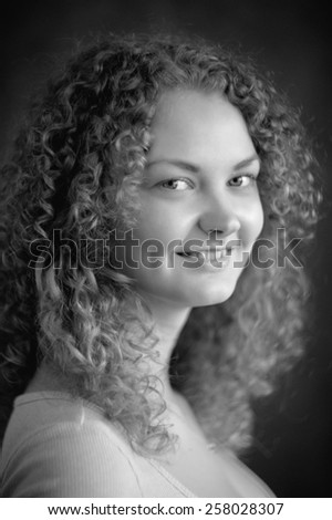 Smiling fairy woman with curly hair, big breast, low neck decollete on dark grey background black&white