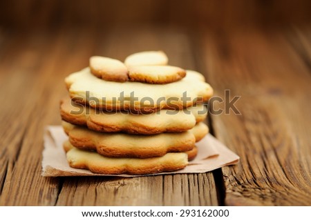Four round sand cakes in pile decorated with three small leave cakes on craft paper close up selective focus