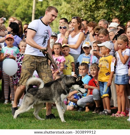 Orel, Russia, August 01, 2015: Mumu Fest, Turgenev\'s story art-festival, man with husky, childrens looking at the dog
