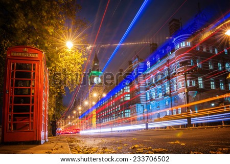 Red phone booth is one of the most famous of London icons with bus blur at night Red phone booth is one of the most famous of London icons with bus blur at night