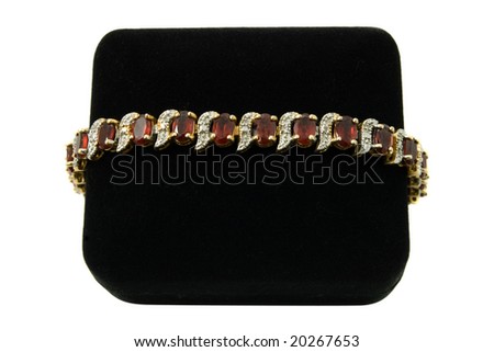 Garnet and diamond gold bracelet set on a black velvet box