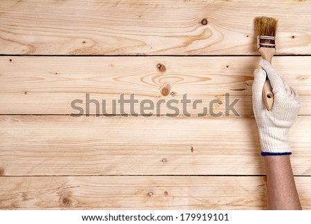 Working hand-in-glove keeping up brush on wooden background