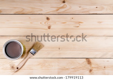 Can of paint and a paint brush on a wooden background